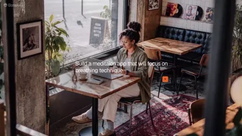 A woman with curly hair at a laptop in a cafe, a prompt about a breathing app over the frame.